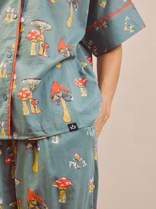 Woman wearing a mushroom patterned oversized pyjama set against a plain background