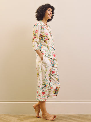 Woman wearing a floral capri pyjama set against a plain background