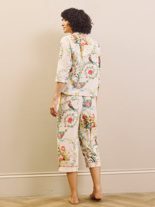 Woman wearing a floral capri pyjama set against a plain background