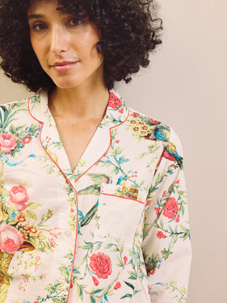 Woman wearing a floral capri pyjama set against a plain background