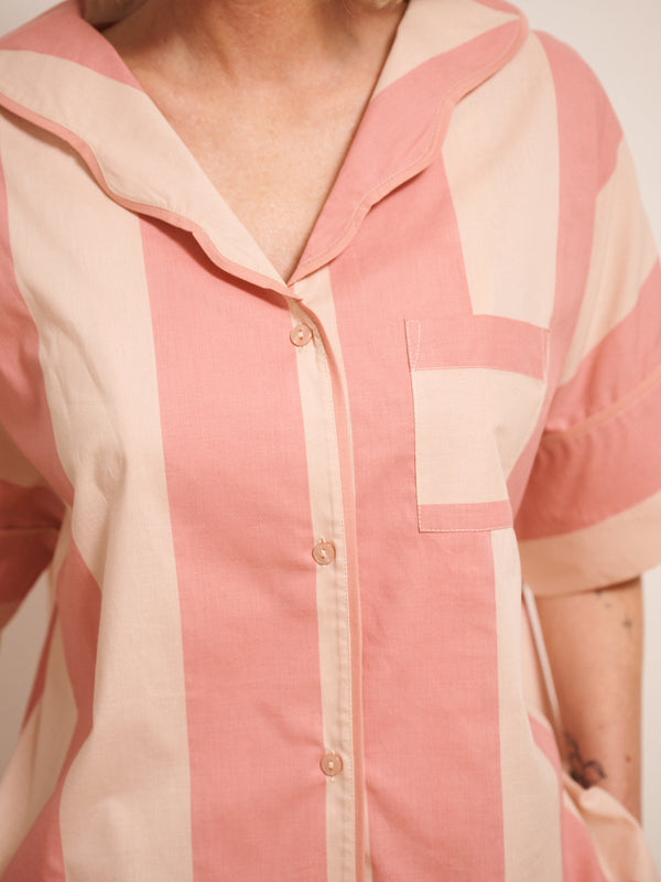 Model wearing a pink and white striped pyjama set against a white background