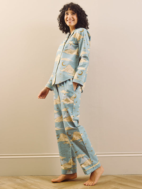 model wears light blue long traditional pyjama set with cloudy sky print