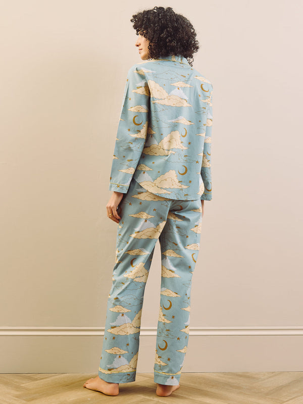 model wears light blue long traditional pyjama set with cloudy sky print