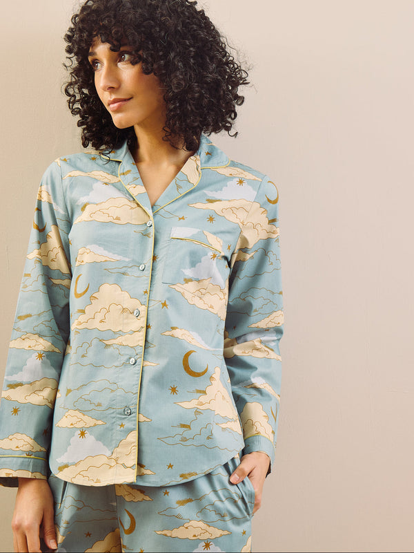 model wears light blue long traditional pyjama set with cloudy sky print
