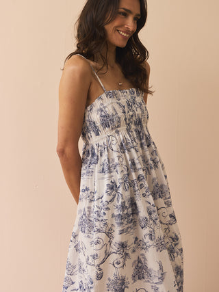 Woman wearing a blue floral nightdress against a beige background