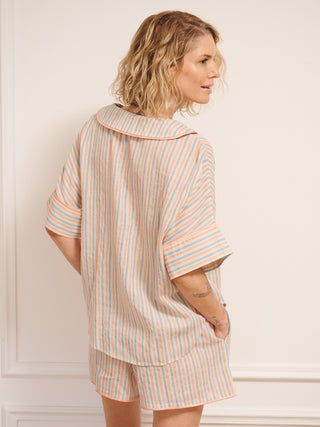Women’s pastel stripe cotton gauze shortie pyjama set with oversized button-up top, short sleeves, open collar and matching shorts with pockets, shown on model indoors. Back detail 
