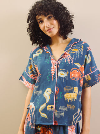 Woman wearing a colorful patterned shirt with a neutral background