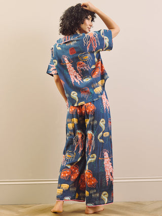 Person wearing a colorful outfit with marine animal patterns against a plain background