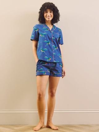 model wears a hummingbird print short pyjama set with a navy blue base 