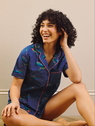 model wears a hummingbird print short pyjama set with a navy blue base 