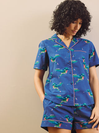 model wears a hummingbird print short pyjama set with a navy blue base 