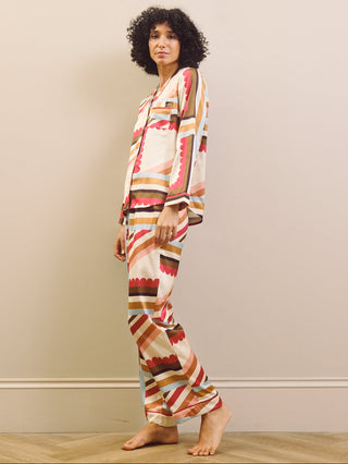 Woman wearing a patterned pyjama set against a plain background