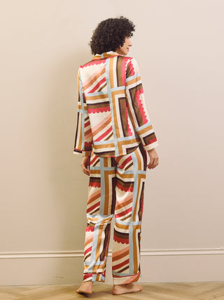 Person wearing a patterned pyjama set standing against a plain wall.