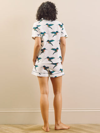 model wears a hummingbird print short pyjama set with a white base, back detail