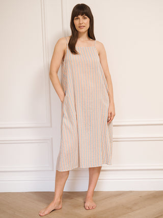 Model wearing women’s cotton gauze midi nightdress with straight neckline and slim straps, featuring baby pastel stripe print and relaxed, flowing fit.