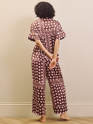 Person wearing a polka dot pyjama set with a neutral background