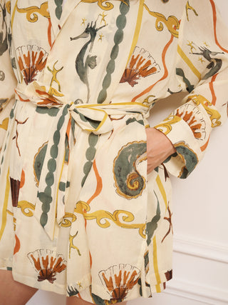 Model wearing women’s cotton voile mini wrap robe in natural with sea life tile print, featuring tie waist, long sleeves and relaxed, lightweight fit. Pocket detail. 