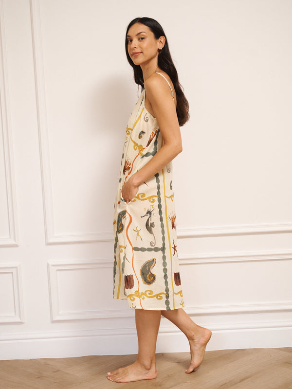 Model wearing women’s cotton voile midi nightdress with straight neckline and slim straps, featuring natural sea life tile print with seahorses, shells and starfish in a relaxed, flowing fit.