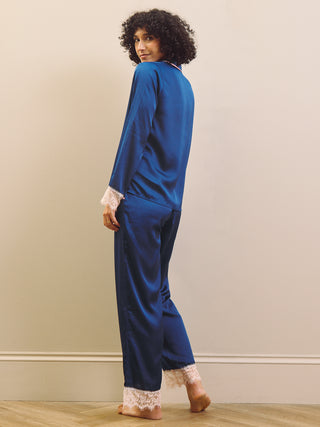 Person wearing a blue pyjama set with lace trim on a plain background