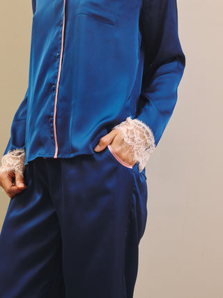 Blue satin pyjama set with lace cuffs on a neutral background