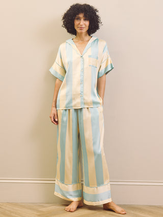 Woman wearing a striped pyjama set against a plain background