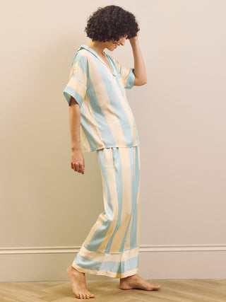 Woman wearing a striped pyjama set against a plain background