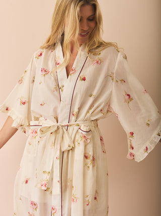 Woman wearing a floral dressing gown robe against a beige background