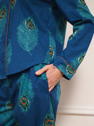 Blue outfit with peacock feather pattern worn by a person. Pocket detail. 