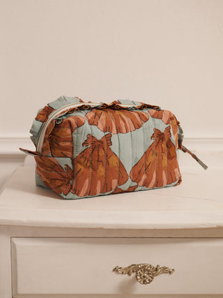 Cosmetic bag with floral pattern on a beige surface