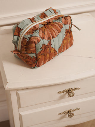 Rectangular pouch with leaf pattern on a white dresser