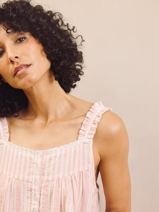 Woman wearing a pink striped night dress against a beige background