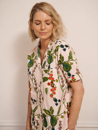 Woman wearing a floral and pear with a neutral background
