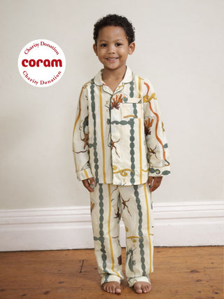 Child wearing sea tile patterned pajamas with Coram logo in the corner