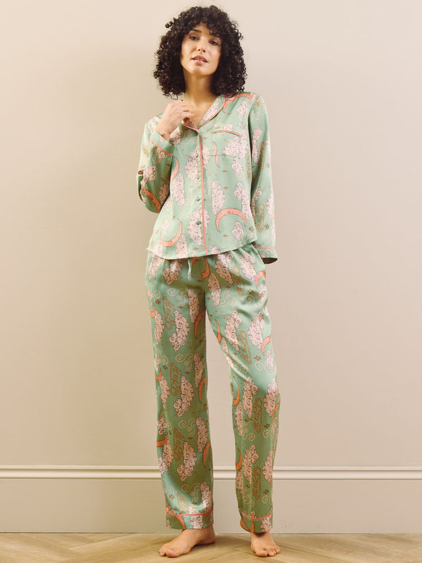 Model wearing a green moon and clouds design long satin pyjama set against a beige background
