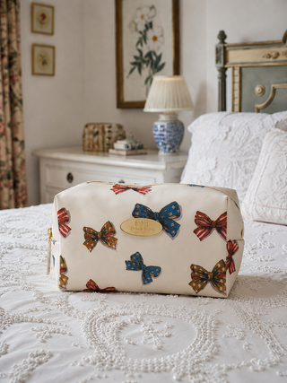 Cosmetic bag with bowdesign on a bed in a bedroom setting