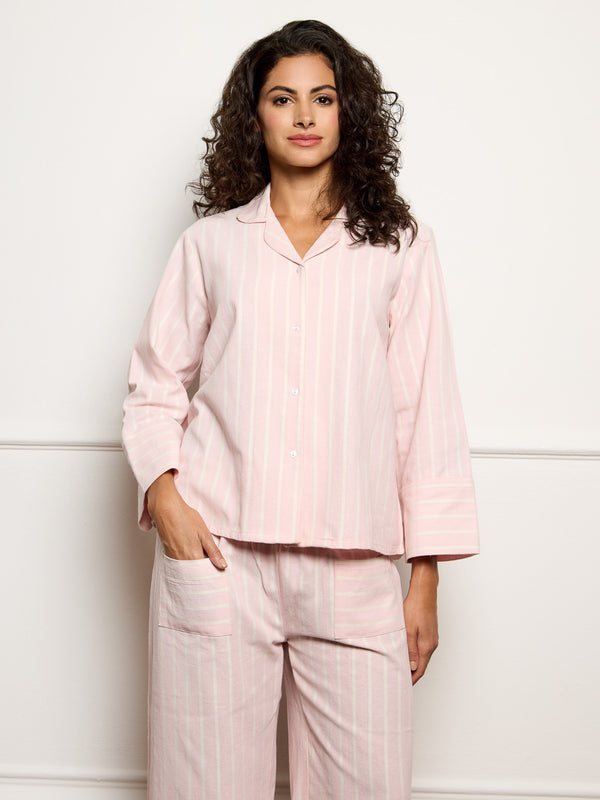 Woman wearing a pink pajama set against a white background