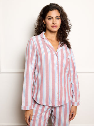 Woman wearing pink and white striped payamas against a white background