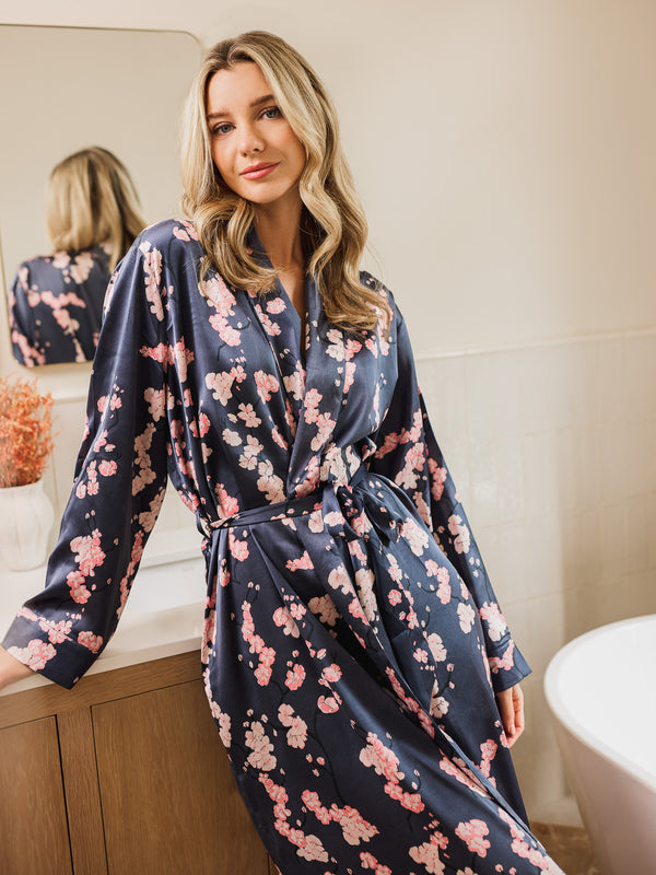 Woman wearing a floral satin robe in a bathroom setting