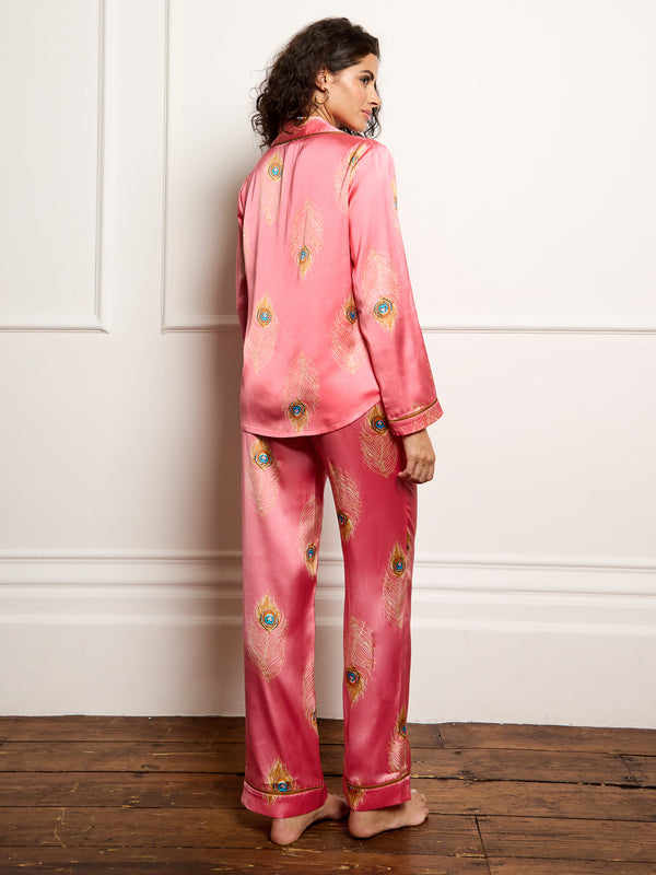 model wears pink peacock feather print satin pyjamas - focus on back