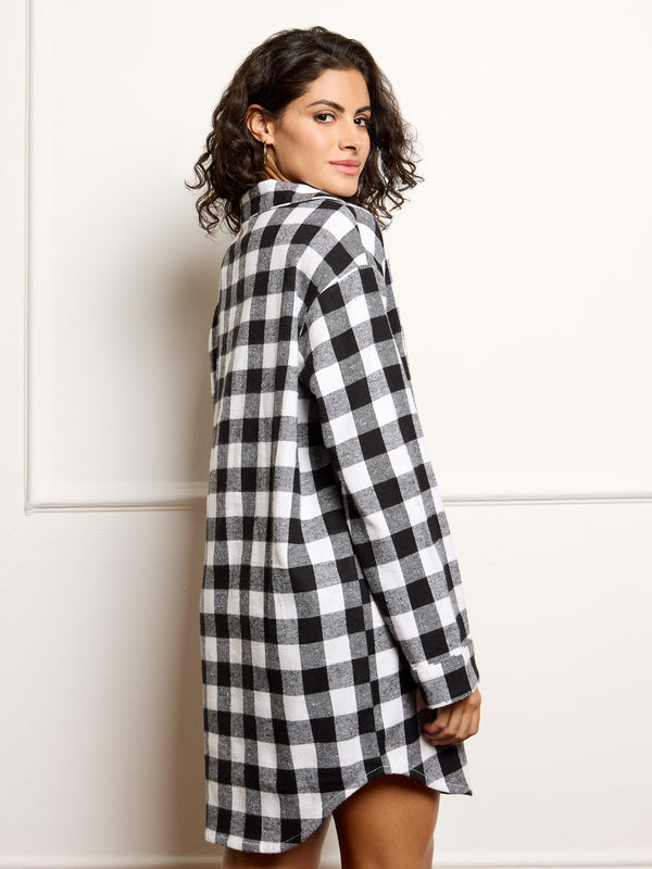 Woman wearing a black and white checkered night shirt against a white background