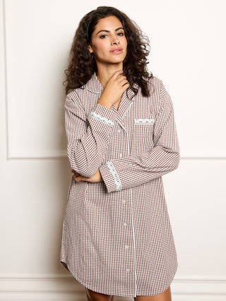 Woman wearing a gingham dress against a white background