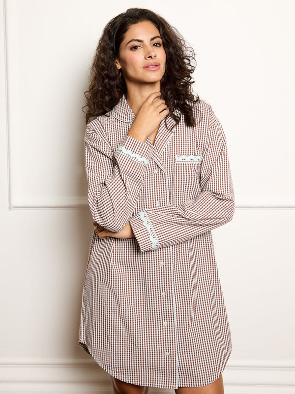 Woman wearing a gingham dress against a white background