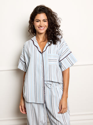 Woman wearing a striped pyjama set against a white background