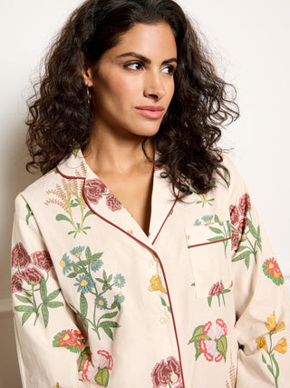 Woman wearing a floral pyjama set against a plain background