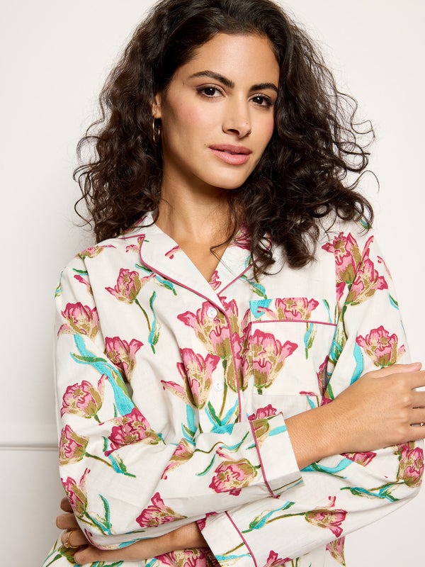 Model wears traditional long cotton pyjamas ion a hand drawn tulip print. close up