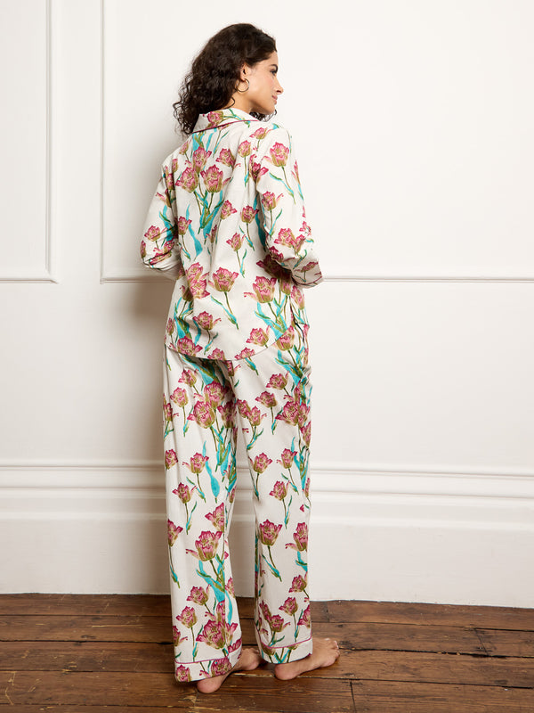 Model wears traditional long cotton pyjamas ion a hand drawn tulip print. Back shot