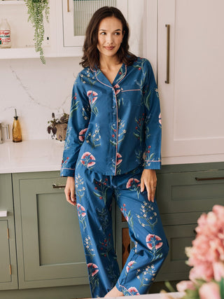 Woman wearing blue floral pyjamas in a kitchen