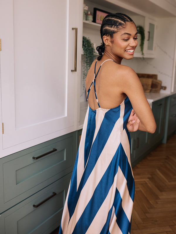Woman in a blue and white striped dress standing in a kitchen.
