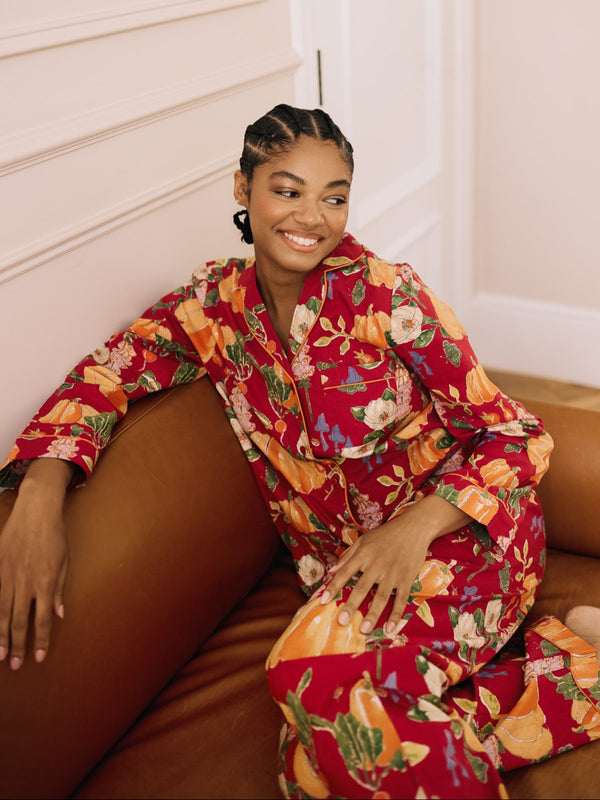 woman wearing a burgundy pyjama set with autumnal pumpkin pattern 