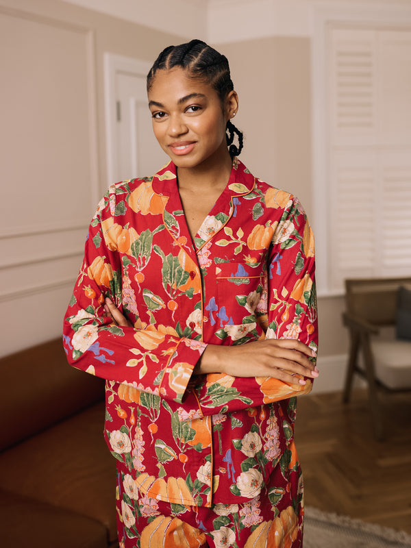 woman wearing a burgundy pyjama set with autumnal pumpkin pattern 